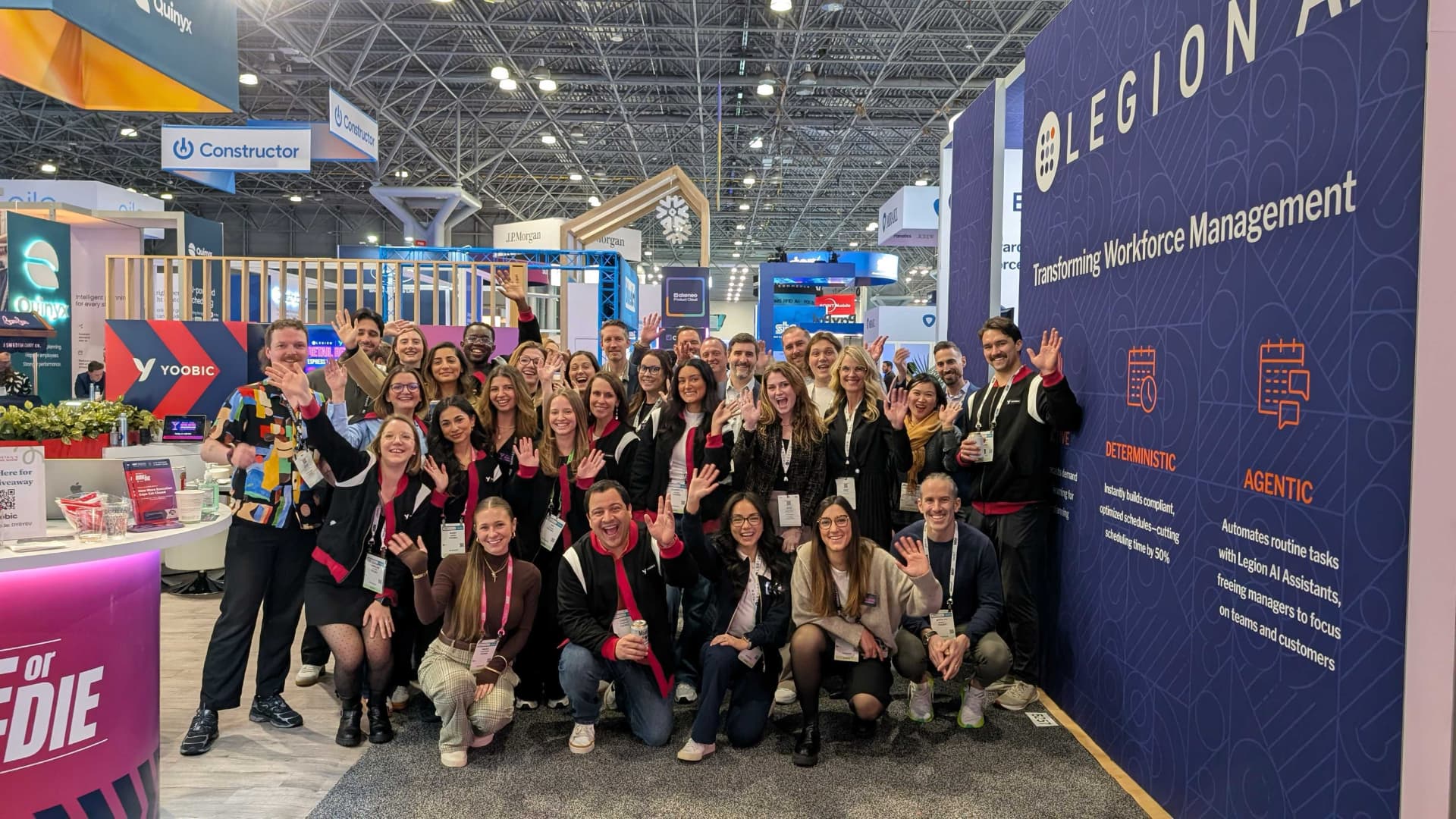 YOOBIC team posing together at the stand at the NRF retail trade show